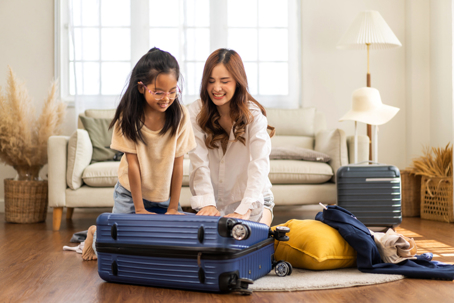 mother and daughter packing a suitcase